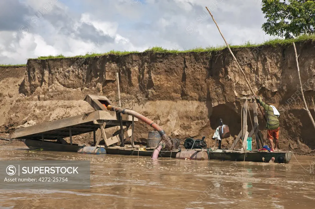 Peru. A floating dredge on the Madre de Dios River, which is used for extracting alluvial gold from the river bed.