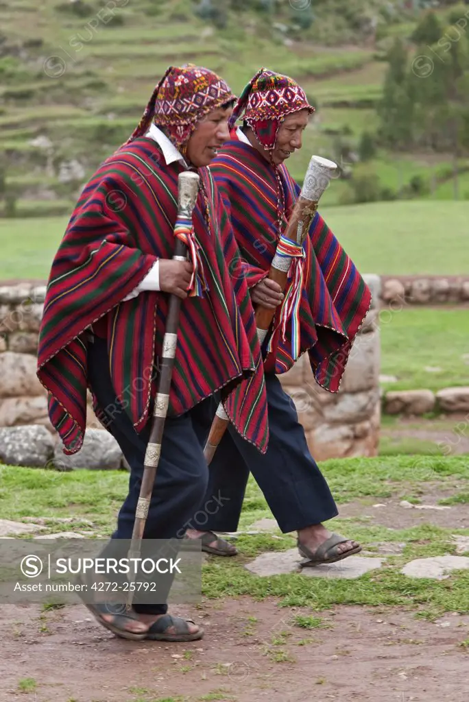 Peru, Elected community representatives, staffs of office in hand, stride along cobblestone paths at Chinchero