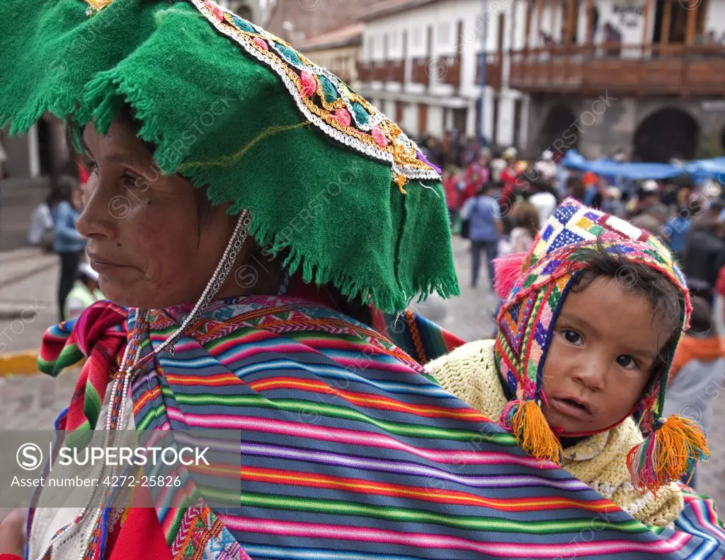 Peru, A Peruvian woman with her child slung on her back at Santuranticuy market. This market is held in the main square of Cusco on Christmas Eve every year.
