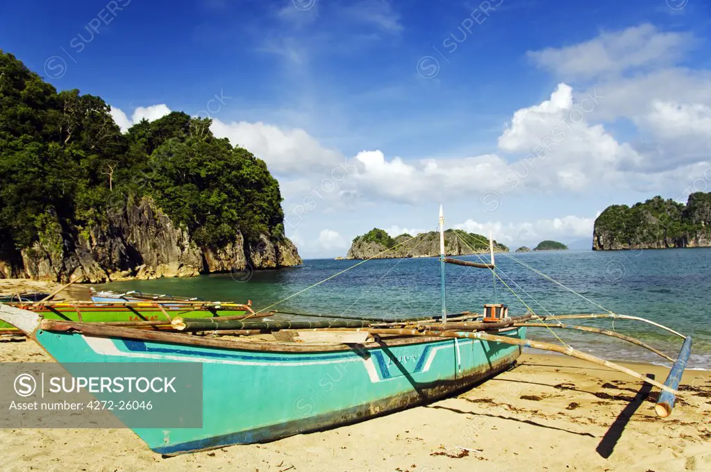 Philippines, Luzon Island, Bicol, Camarines Sur. Caramoan National Park. A fishing catamaran on Gota Beach.