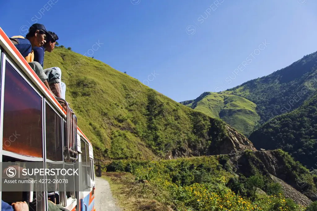 Philippines, Luzon Island, The Cordillera Mountains, Mountain Province. Passengers riding on top of a bus on a journey into the mountains of Kalinga.