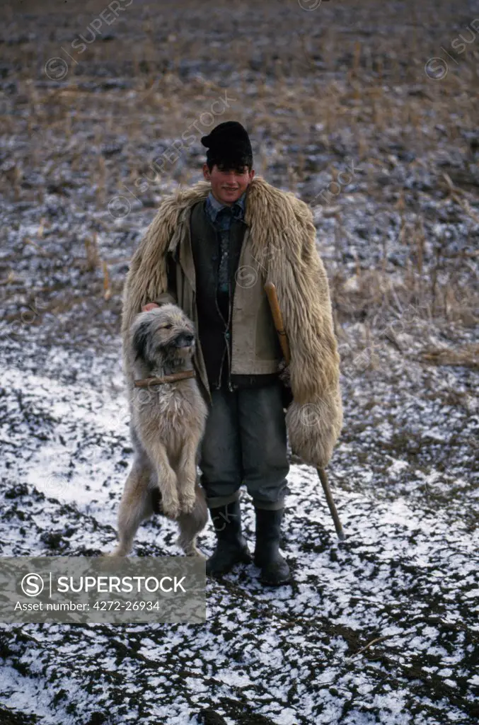 Local shepherd with traditional sheep skin coat and dog