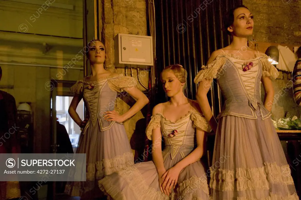 Russia, St.Petersburg; Three ballet dancers waiting in the wings, reminiscent of a Pre-Raphaelite painting, The performance is Tchaikovsky's 'Nutcracker'