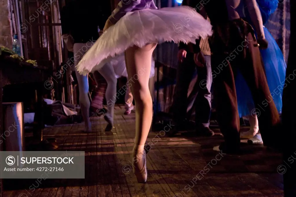 Russia, St.Petersburg; A ballerina wearing a tutu on tip-toes warming-up just before a performance of Tchaikovsky's 'Swan Lake'