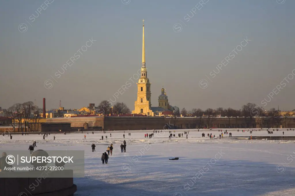 Russia, St.Petersburg; A winter scene on the frozen Neva river with people walking to Peter and Paul Fortress on Vassilevsky Island