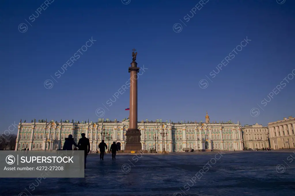Russia, St.Petersburg; A couple walking in Palace Square in front of the Winter Palace, part of the Hermitage Museum of Art.