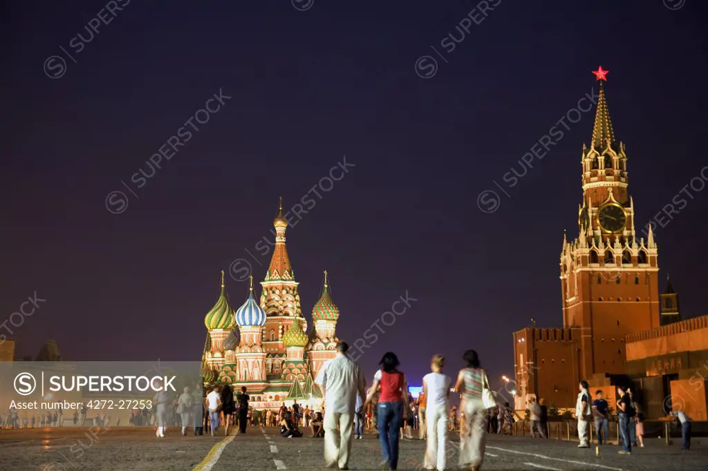 Russia, Moscow;  Muscovites and tourists, Red Square, with a clock tower from the Kremlin and St.Basil's Cathedral