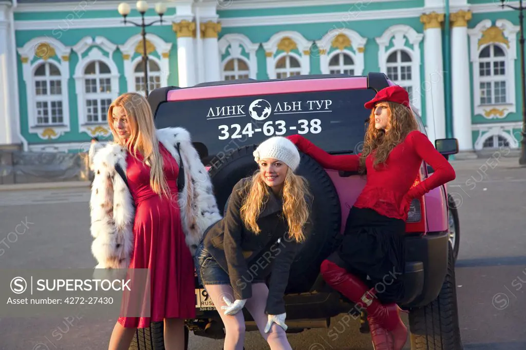 Russia, St. Petersburg; Three Russian girls posing for a commercial in front of the State Hermitage Museum of Art