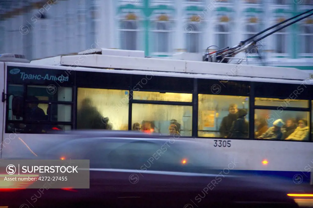 Russia, St. Petersburg; A trolley bus passing in front of the State Hermitage Museum in the evening