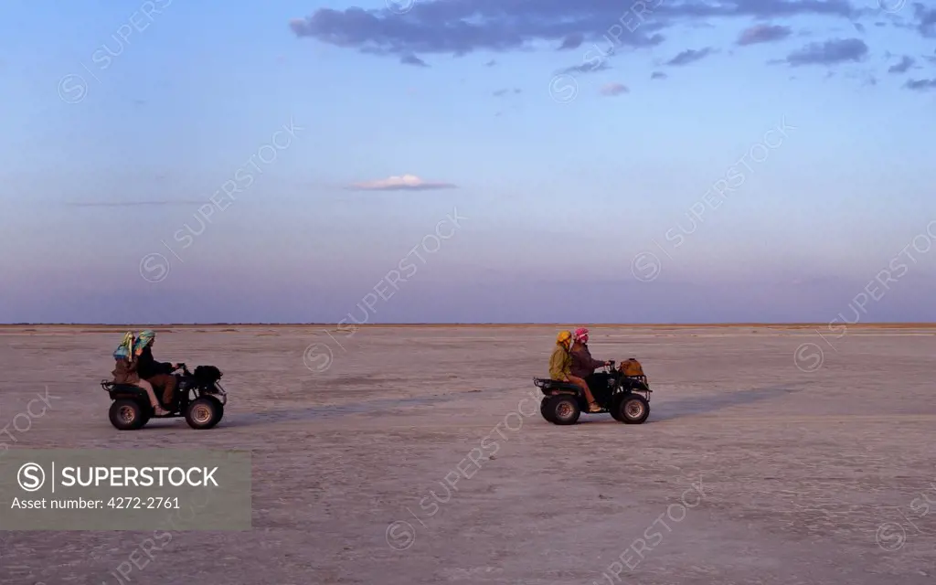 In the late afternoon, visitors cross the featureless Ntwetwe saltpan by quad bike.  ,Ntwetwe is the western of two huge saltpans, which comprise the immense Makgadikgadi region of the Northern Kalahari _ one of the largest expanses of saltpans in the world.