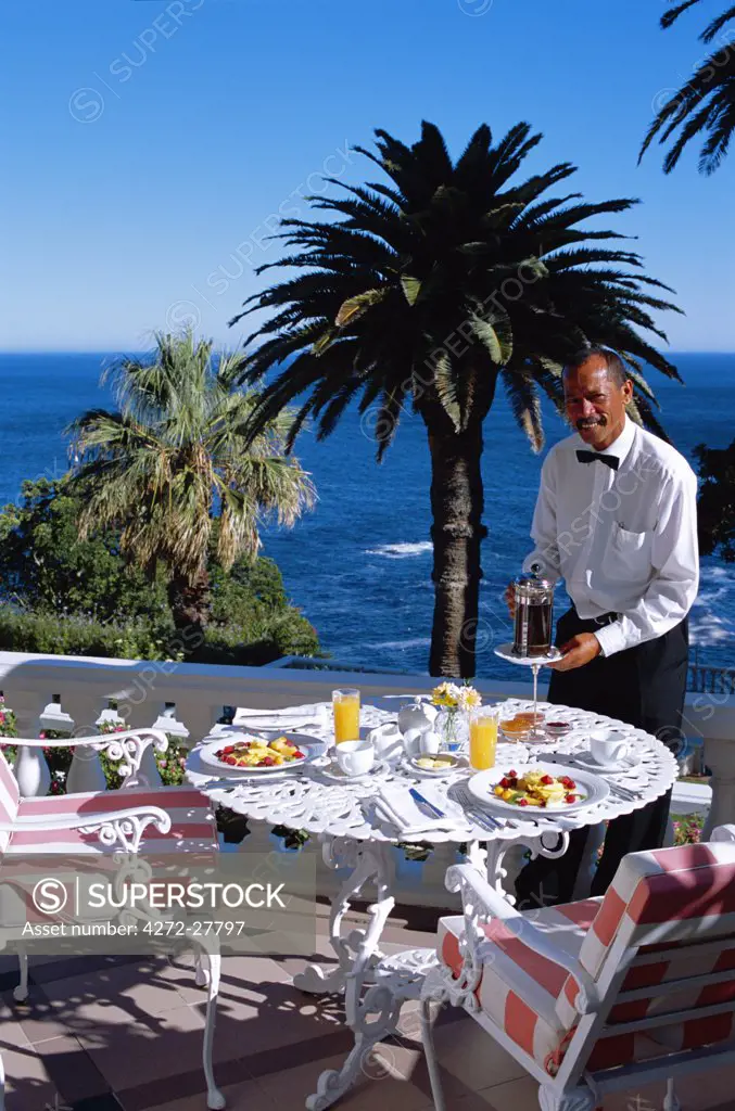 A waiter serves breakfast on the terrace at The Ellerman House