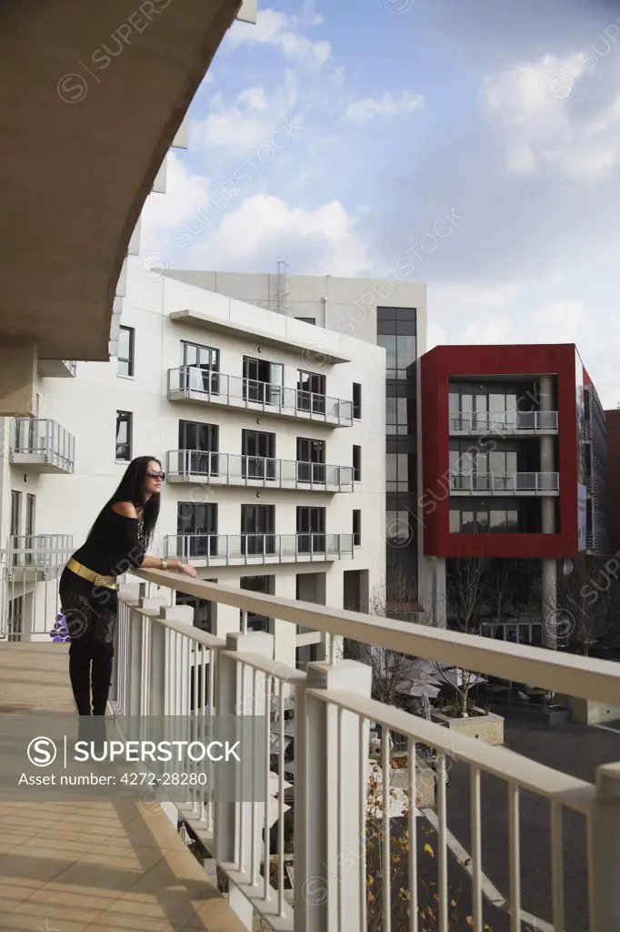 Woman standing on balcony overlooking Melrose Piazza, Melrose, Johannesburg, Gauteng, South Africa (MR)