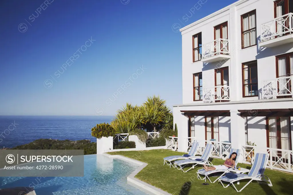 Woman relaxing poolside at Plettenberg Bay Hotel, Plettenberg Bay, Western Cape, South Africa (MR)