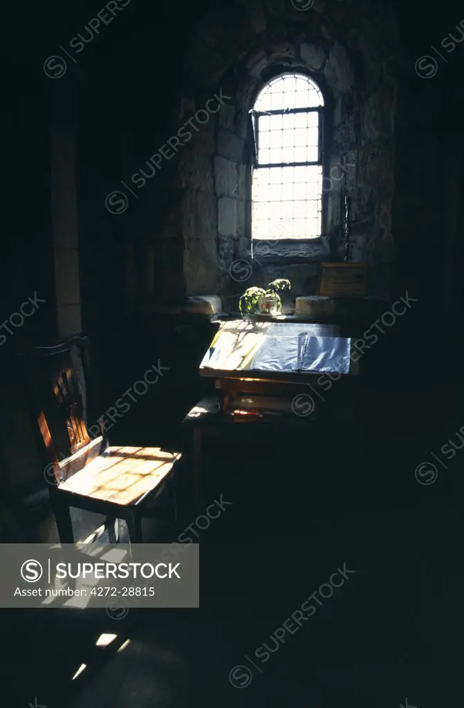 Chapel window and illuminated Bible and table