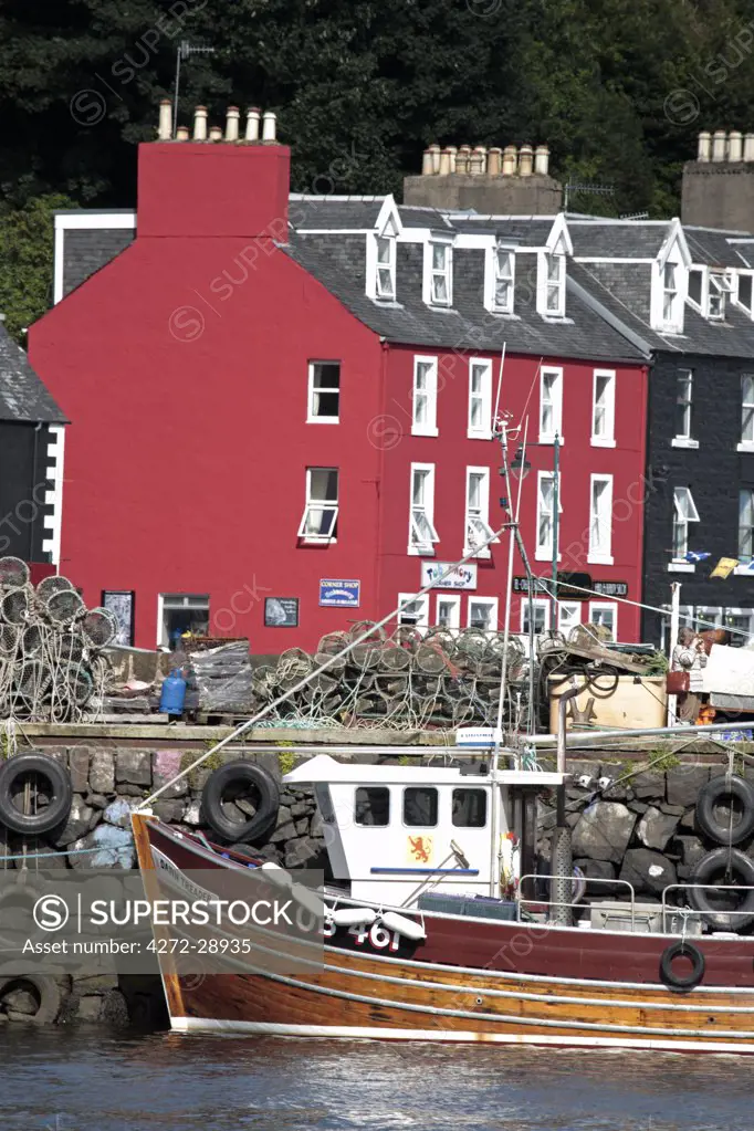 Scotland, Isle of Mull. Fishing boat and colourful waterfront houses at Tobermory harbour.