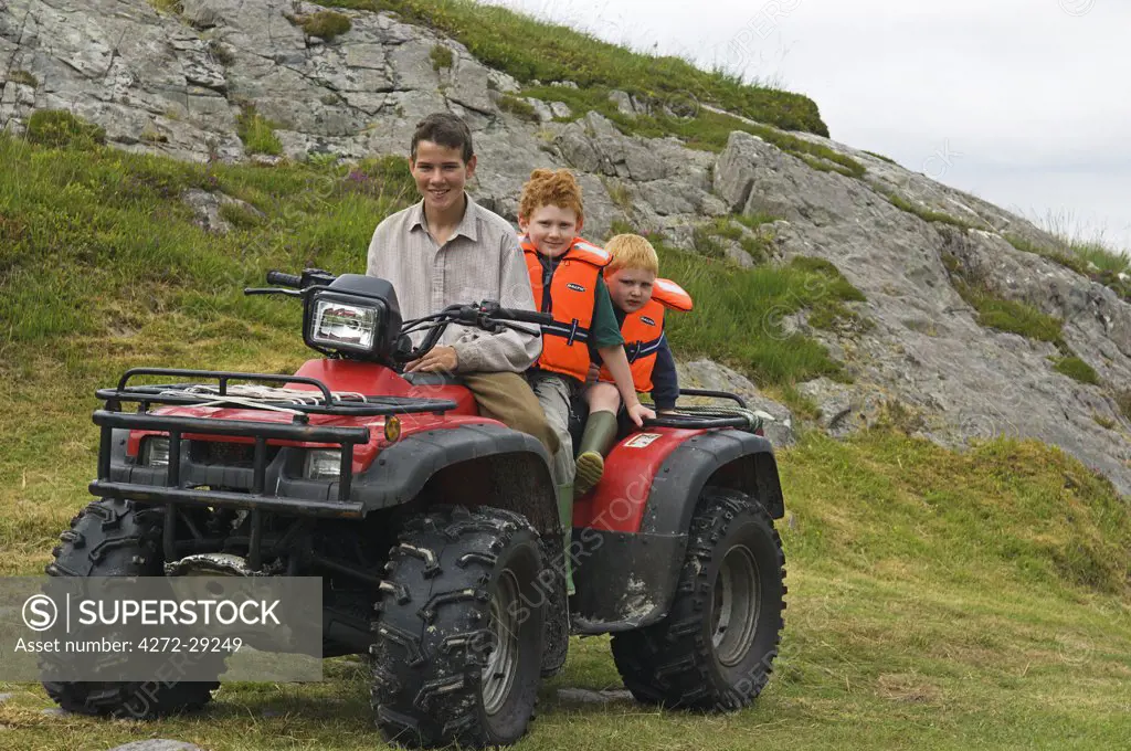 Young guests at GlenBatrick Lodge ride on the quad bike with one of the under keepers.  Glen Batrick overlooks the white sandy shore of Loch Tarbert on the west side of Jura.