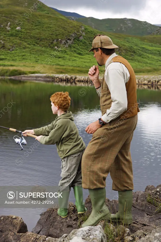 Gordon Muir, stalker and ghillie at Glen Batrick Lodge, teaches a young guest to fish