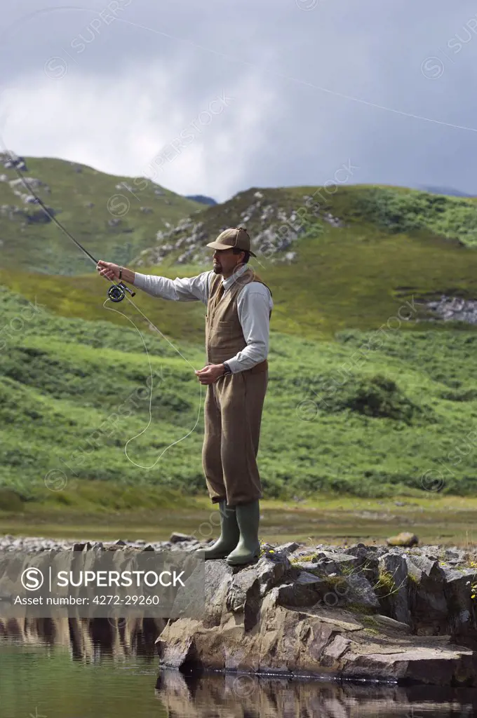 Gordon Muir, stalker and ghillie at Glen Batrick Lodge, fly fishing for trout on a hill loch