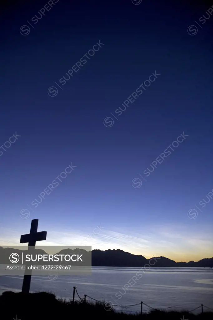 South Georgia Island, Cumberland Bay.   Sunrise over the bay and the cross erected by Sir Ernest Shackeltons crew as a memorial to his death from a heart attack at the whaling station at Grytiviken.