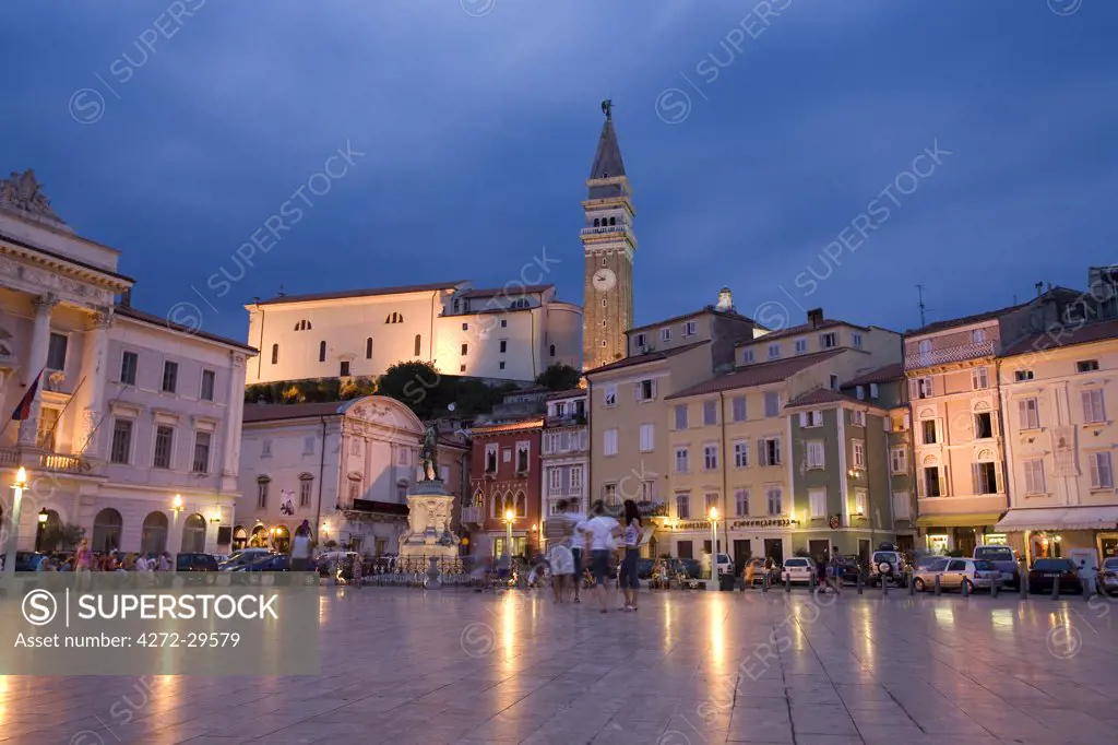 Slovenia, Piran. Evening view of Tartini Square in Piran on the shores of the Adriatic Sea; the spire of St George Cathedral rising above the town.