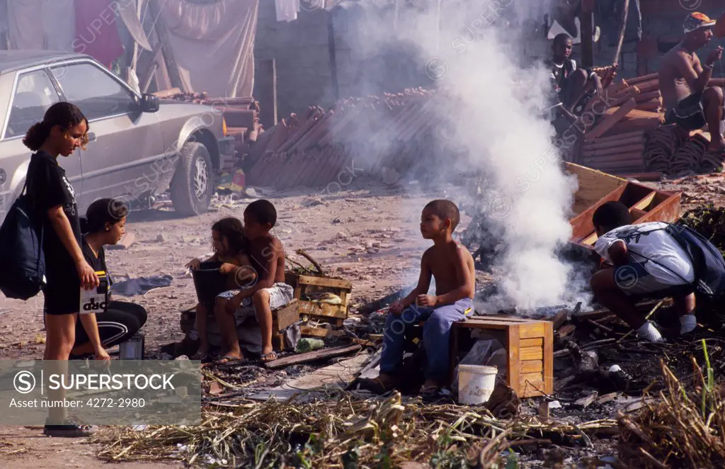 Children sit by a bonfire in a favela in Sao Paulo