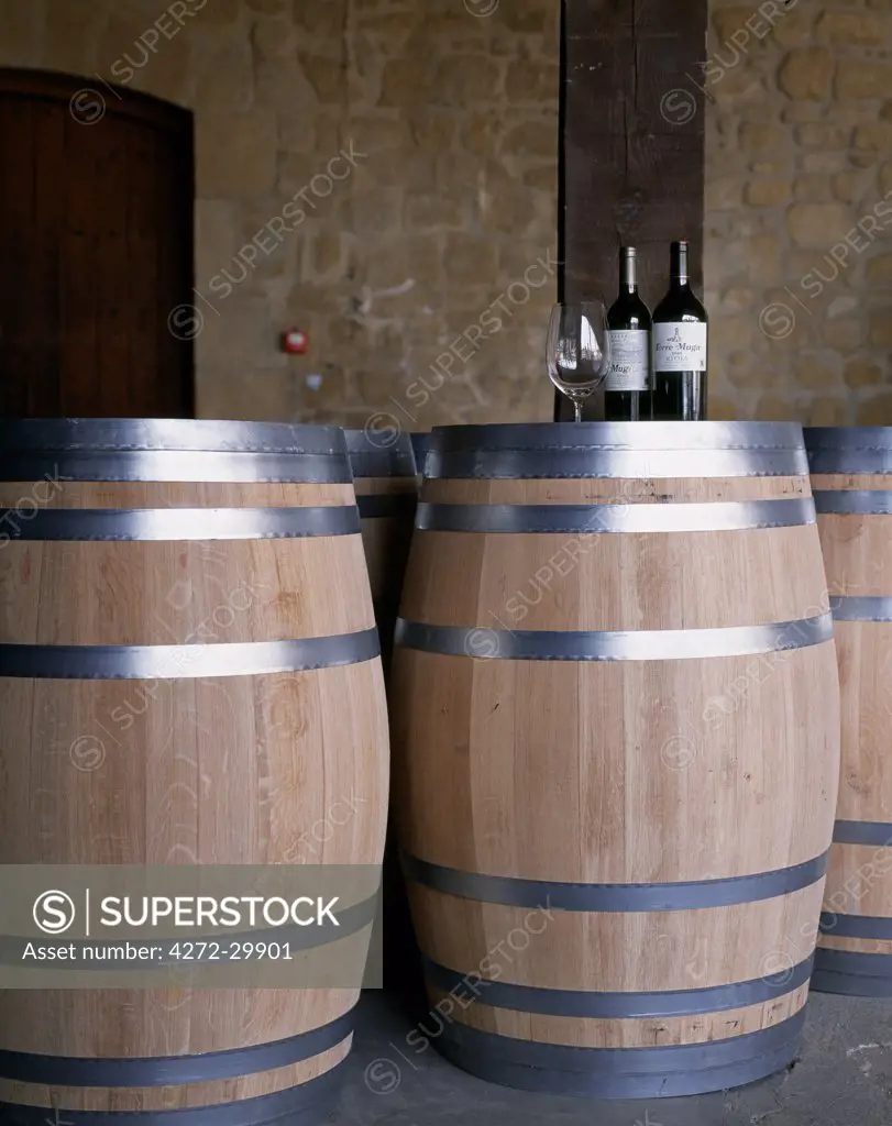 Bottles of Muga Reserva and Torre Muga on top of new wine barrels at Muga winery