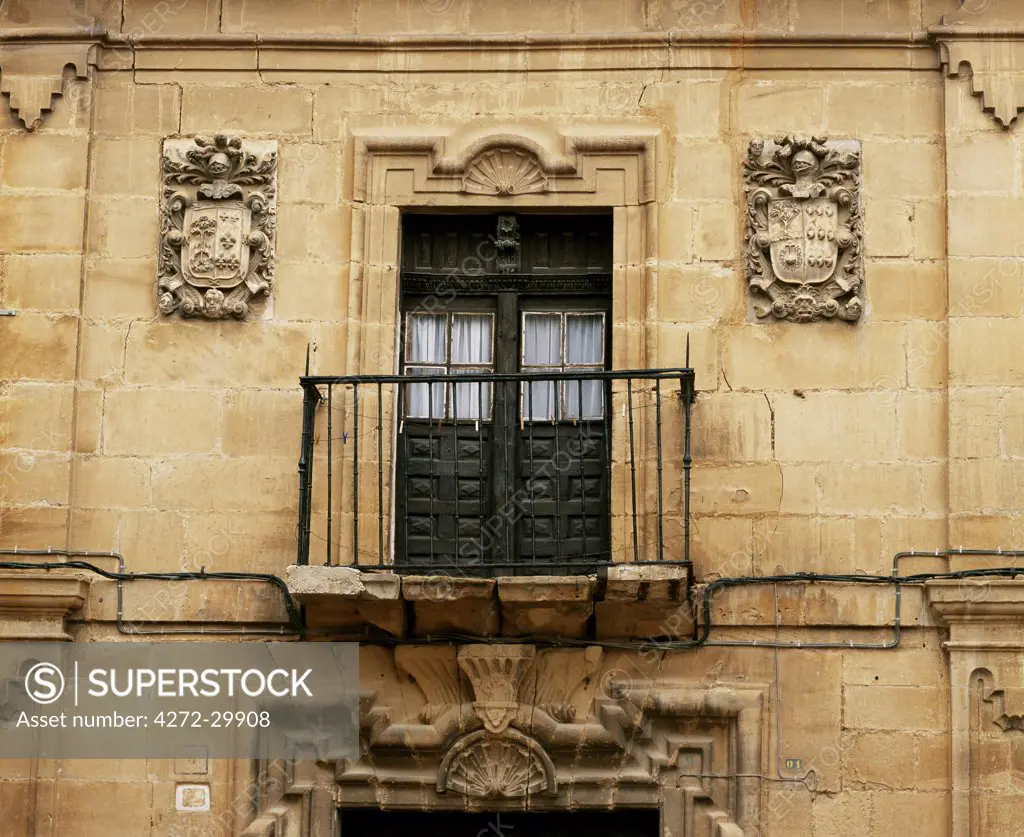 Details of carved armorial shields and a window and wrought iron balcony on a mansion in Haro