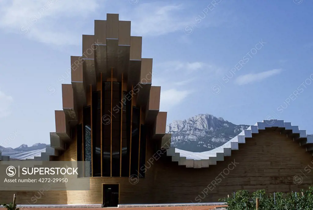 The striking architecture of Ysios winery, designed by world renowned architect Santiago Calatrava, mirrors the undulations of the limestone mountains of the Sierra de Cantabria rising behind