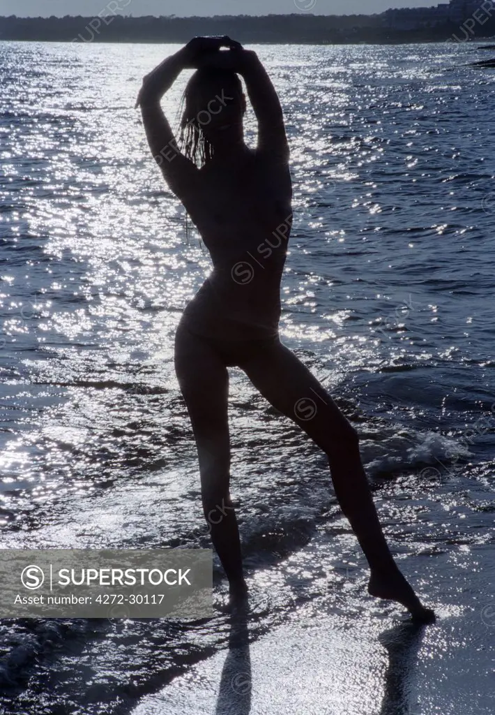 Model posing on the beach in silhouette