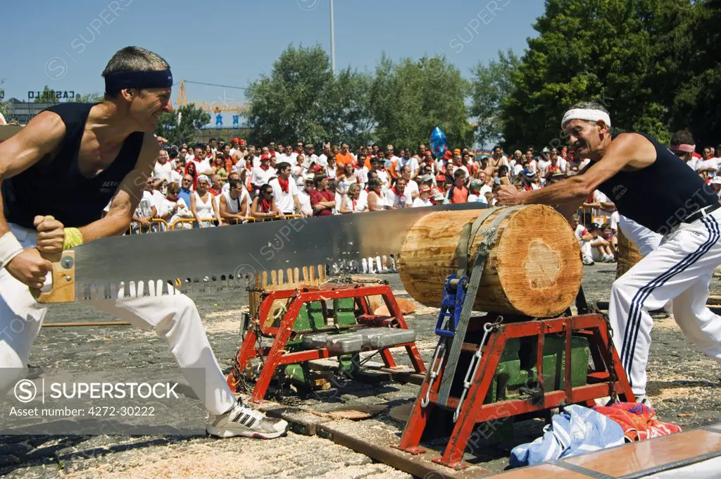 Strong Man Competition During San Fermin Running of the Bulls Festival Log Cutting. The celebration, which honours the city's patron saint, San Fermin - includes fireworks, parades, dances, bullfights and religious ceremonies.