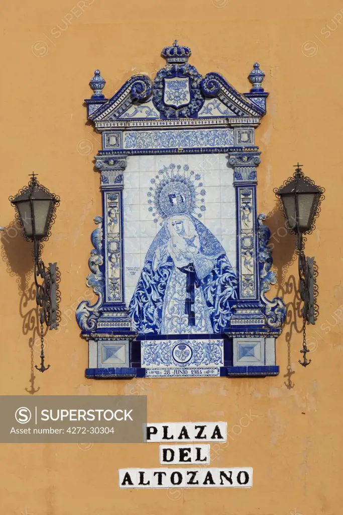 Spain, Andalucia, Seville. An elegant ceramic sign with wrought iron lanterns on a street corner in Plaza del Altozano.