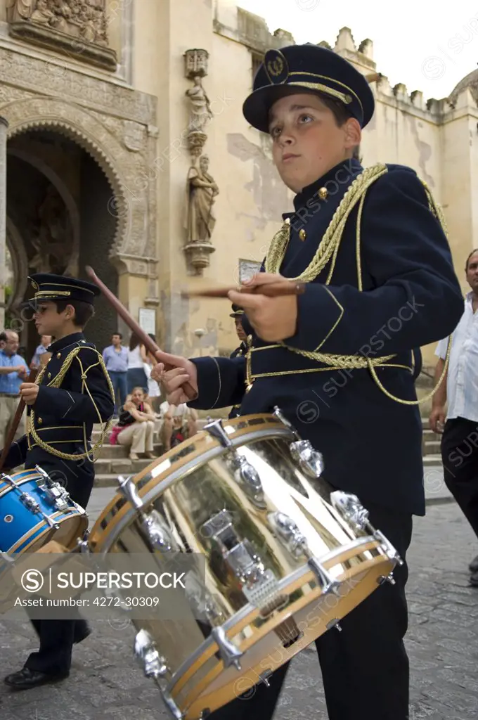 Spain, Andalucia, Seville. A drummer boy in the uniform of the band of one of the Catholic brotherhoods of Seville.