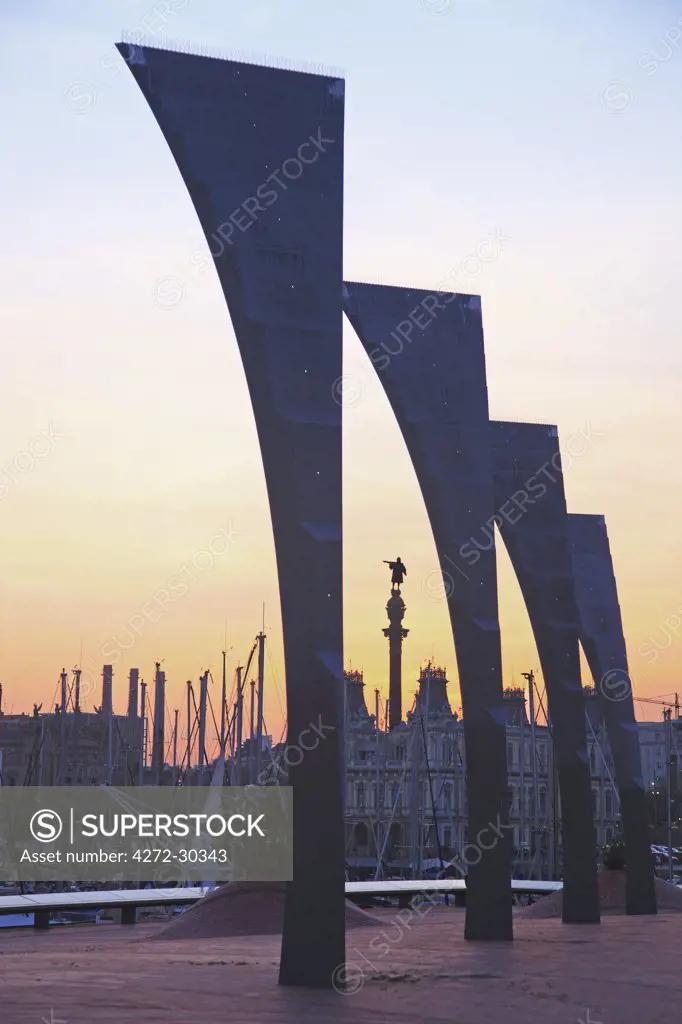 Spain, Cataluna, Barcelona, la Barceloneta, Sculpture at sunset with Barcelona Marina in the background.