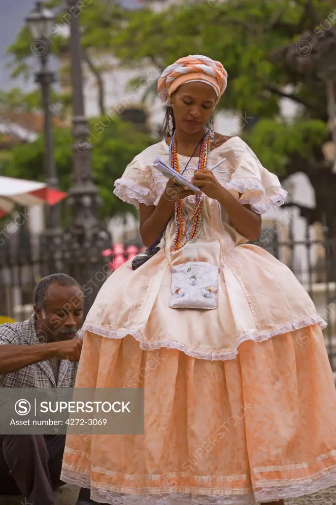 Local lady wearing traditional Bahian dress reflecting the area's colonial past in the UNESCO city of Salvador da Bahia, North East Brazil