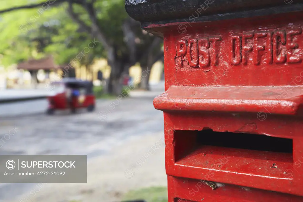 Red post box with tuk tuk in background, Galle, Sri Lanka