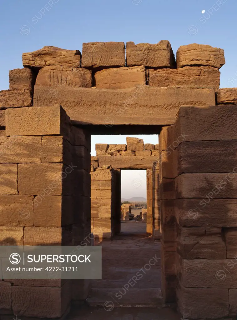 Bathed in early morning sunlight with a full moon still evident in the sky, this ruins of a temple dedicated to Amon is one of the four temples situated beside an important wadi at Naga some 30 km from the Nile.