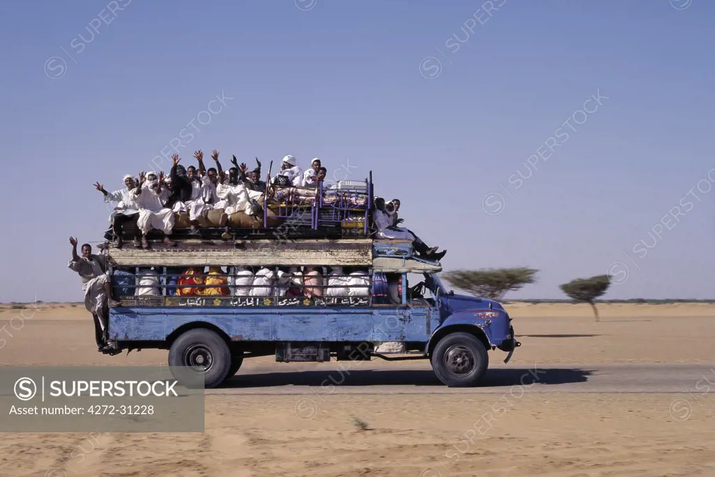 An over-crowded old Bedford bus travels along the main road from Khartoum to Shendi, a centuries old market town on the River Nile.