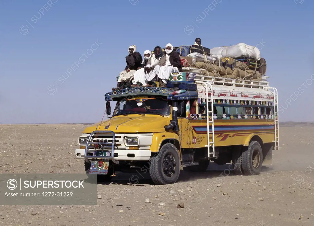 A heavily-laden bus travels across the Nubian Desert east of the River Nile in Northern Sudan.