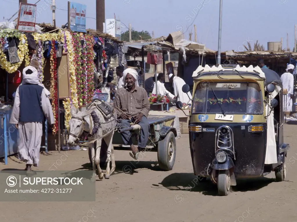 Ancient and modern transport plys the dusty streets of the important market town of Karima. Indian-made three-wheeled Bajaj taxis have become popular forms of modern transport in towns throughout The Sudan.