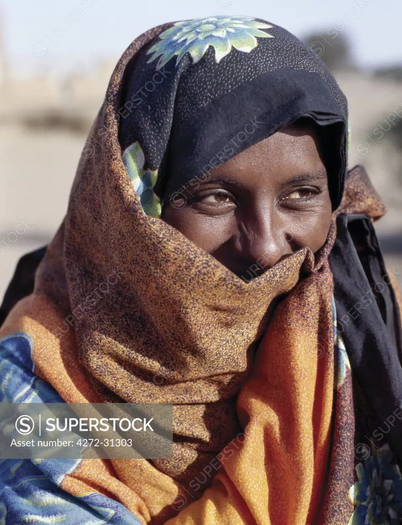 An attractive Nubian woman in bright clothing, the lower part of her face covered by her headscarf.
