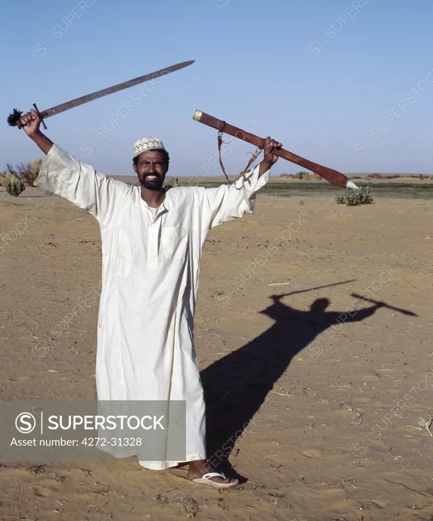 A Nubian man displays his sword at an oasis in the Nubian Desert north of Old Dongola.