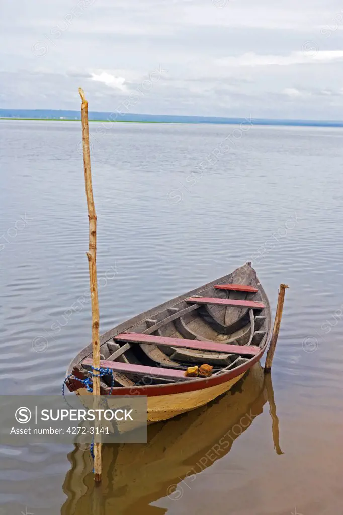 Brazil, Amazon, Rio Tapajos. A tributary of the Rio Tapajos which is itself a tributary of the Amazon. A fishing boat is secured to the river bank near the village of Jamaraqua.