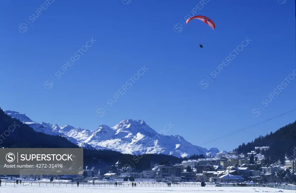 A paraglider comes into land on the frozen lake