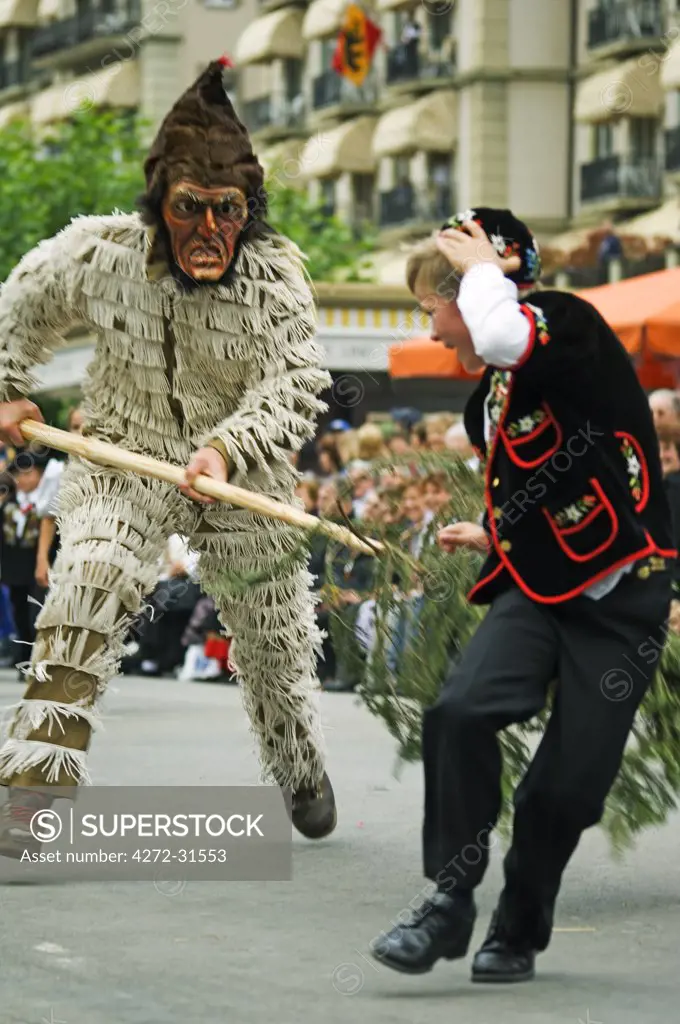 A Devil in costume chasing a young boy at the Unspunnen Bicentenary Festival, Interlaken, Jungfrau Region, Switzerland