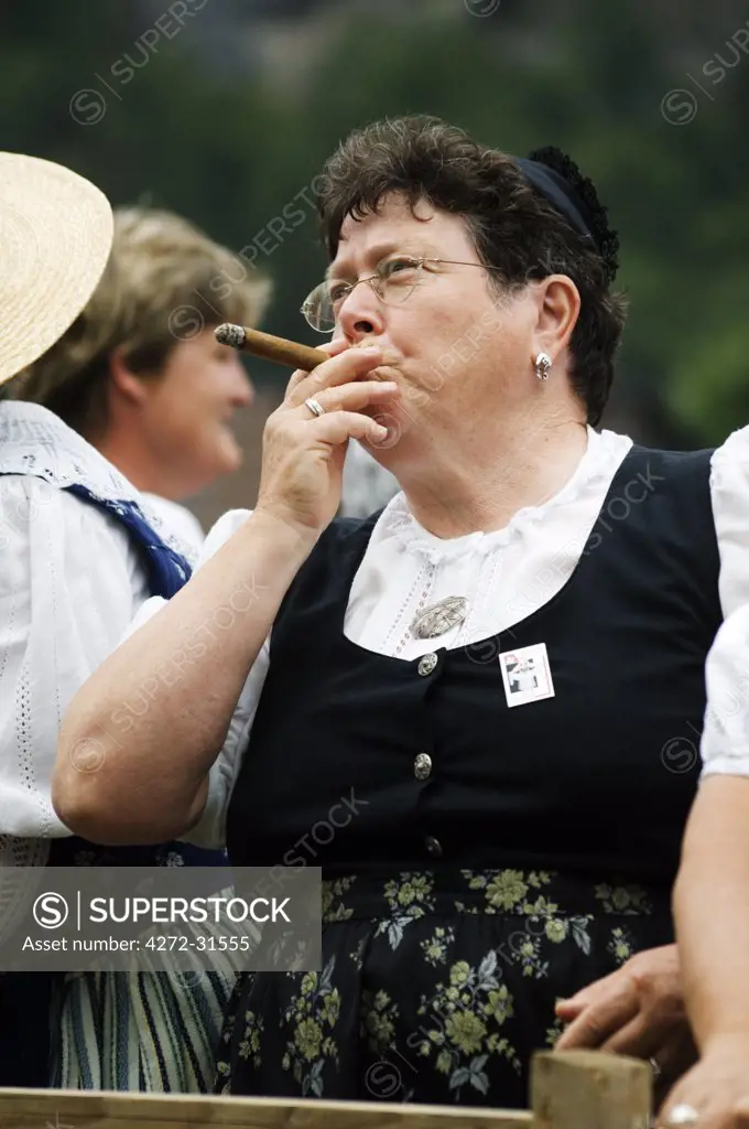 A woman smoking a cigar at the Unspunnen Festival Bicentenary, Interlaken, Jungfrau Region, Switzerland