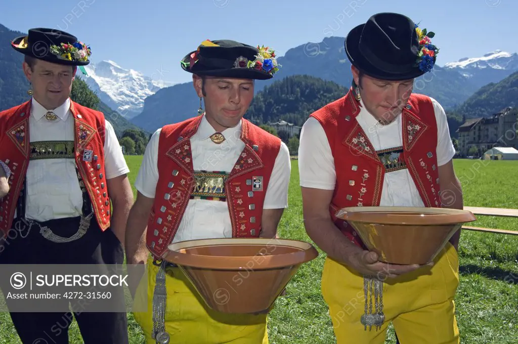 Cow bell ringers in traditional alpine costume practising coin spinning at the Unspunnen Bicentenary Festival, Interlaken, Jungfrau Region, Switzerland