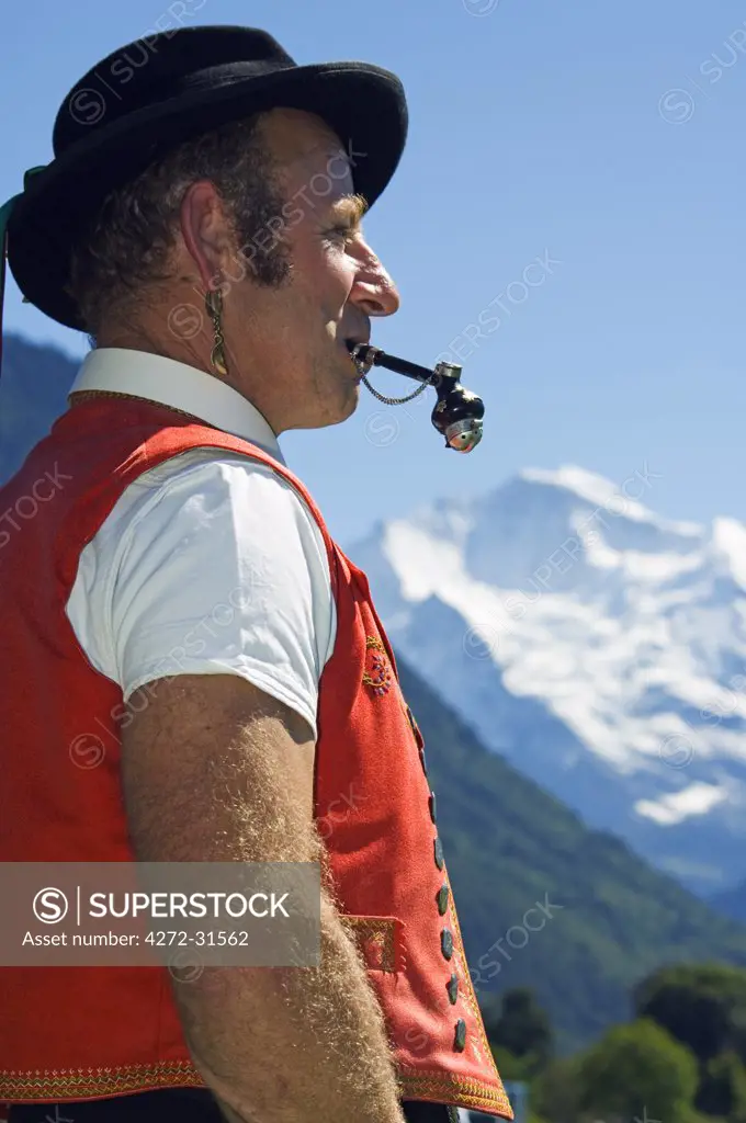 A Swiss man smoking a pipe in traditional alpine costume at the Unspunnen Bicentenary Festival, Interlaken, Jungfrau Region, Switzerland