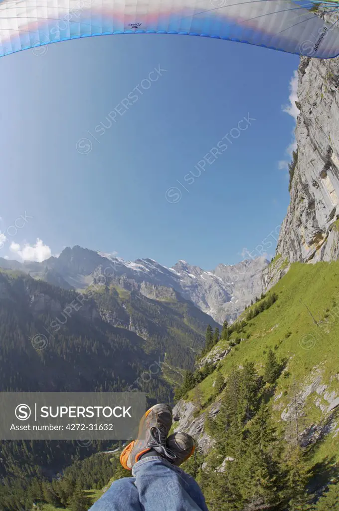 Switzerland, Bernese Oberland, Murren. A paraglider taking in the alpine views over Murren.