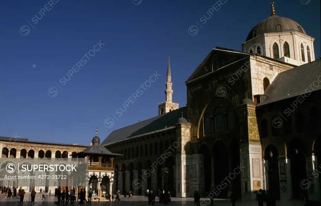Syrians sit around an ablution kiosk in the marble courtyard of the 8th Century Omayyad Mosque, among the Islamic world's greatest monuments