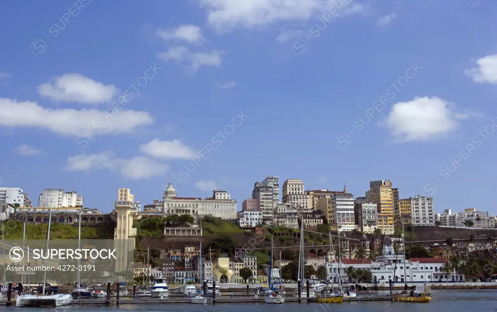 Brazil, Bahia, Salvador. Within the historic Old City, a UNESCO World Heritage site, a view from the sea of both the modern and the historic city with the marina in the foreground.
